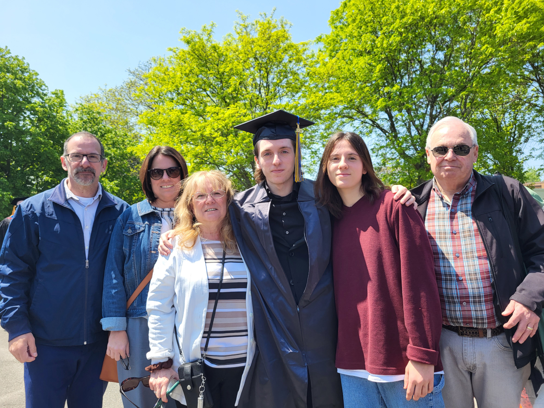 Graduate and family members, standing for photo, smiling