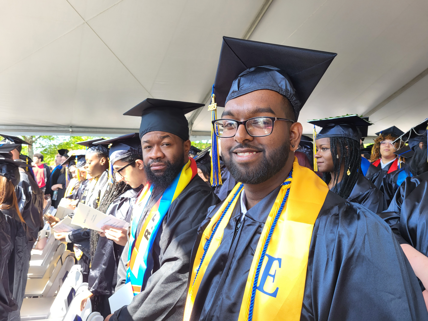 Grads seated, smiling at camera