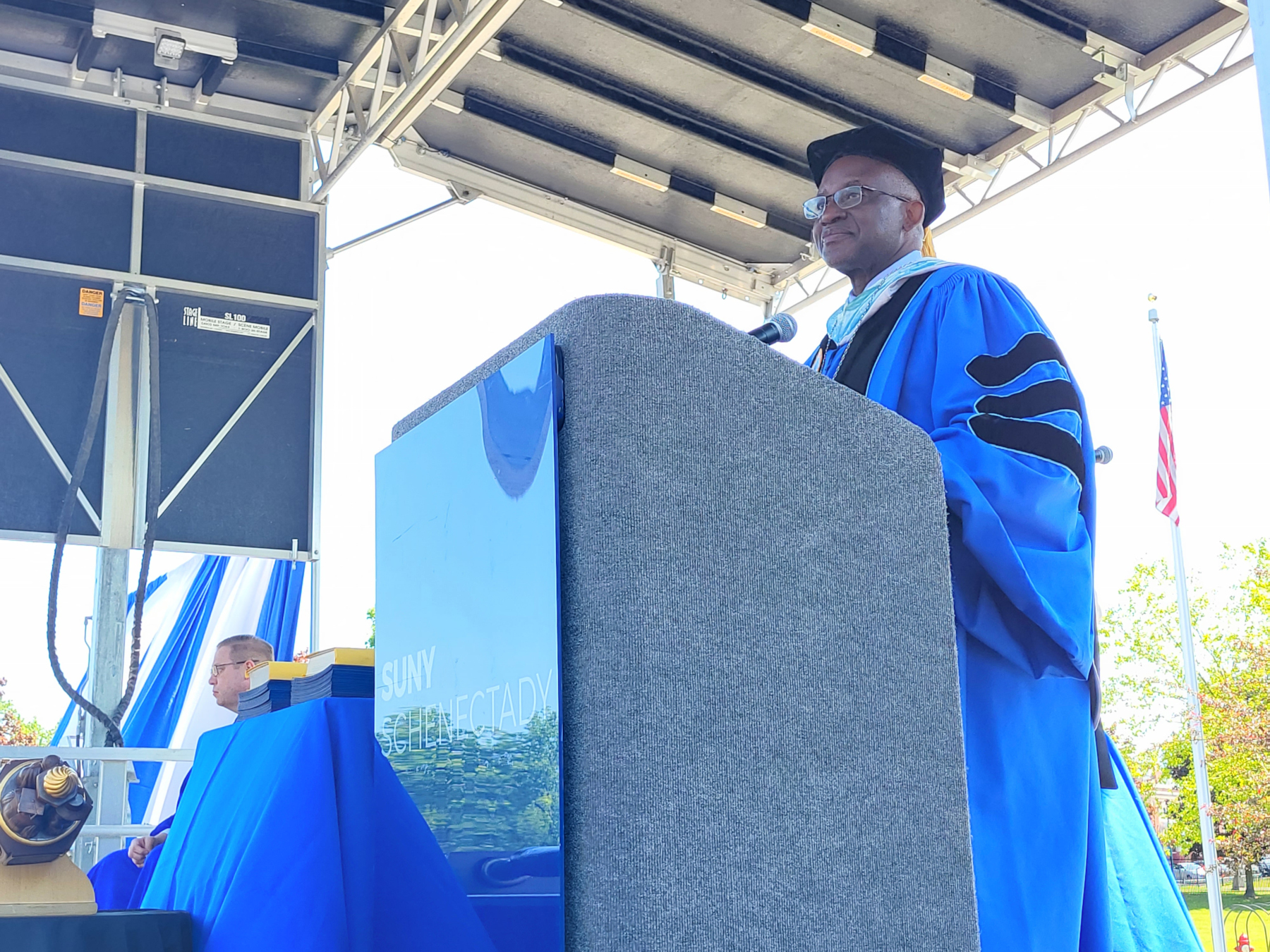 Dr. Moono speaking at podium, on stage