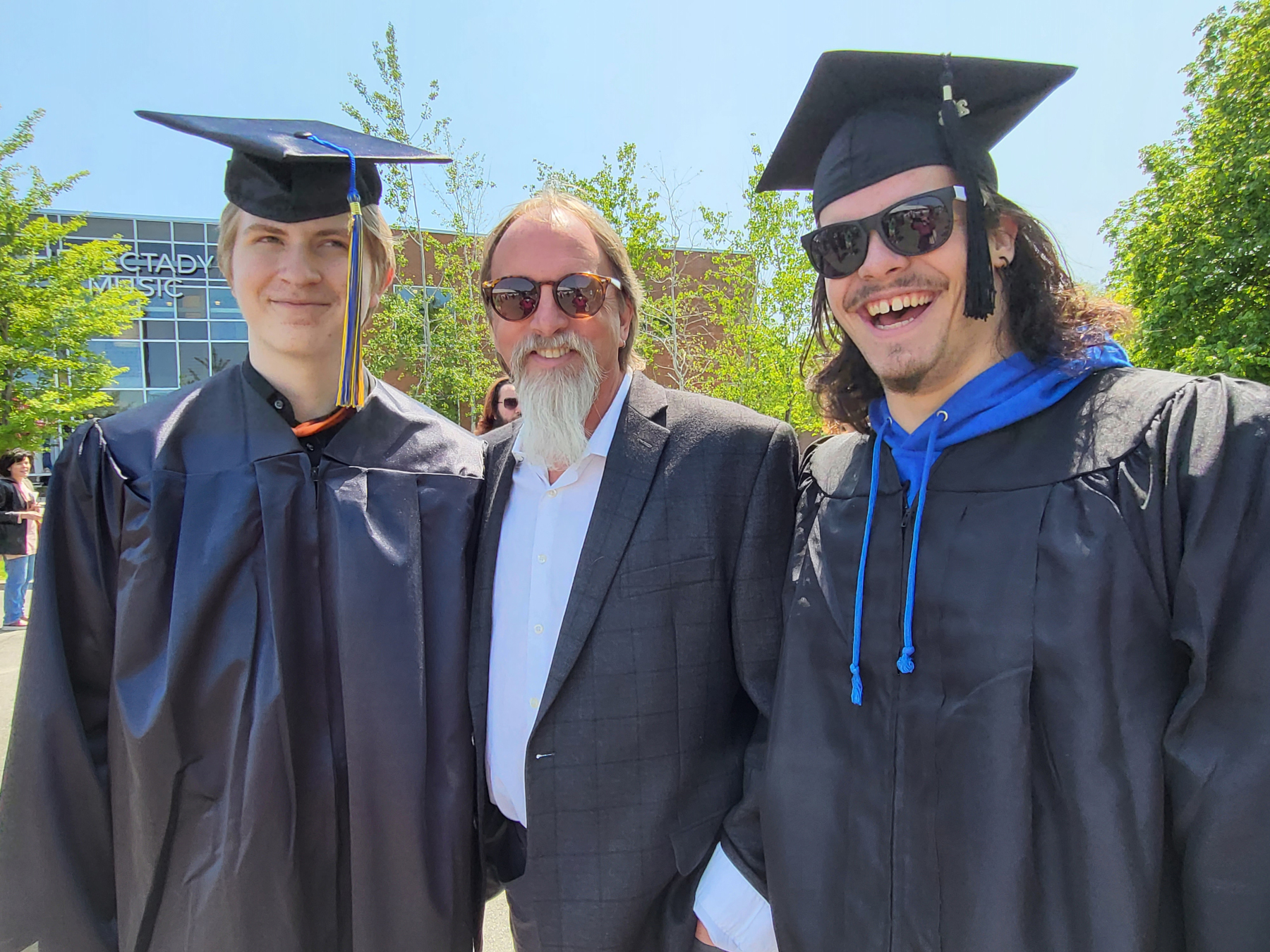 Sten Isachsen with music graduates, outside, smiling 