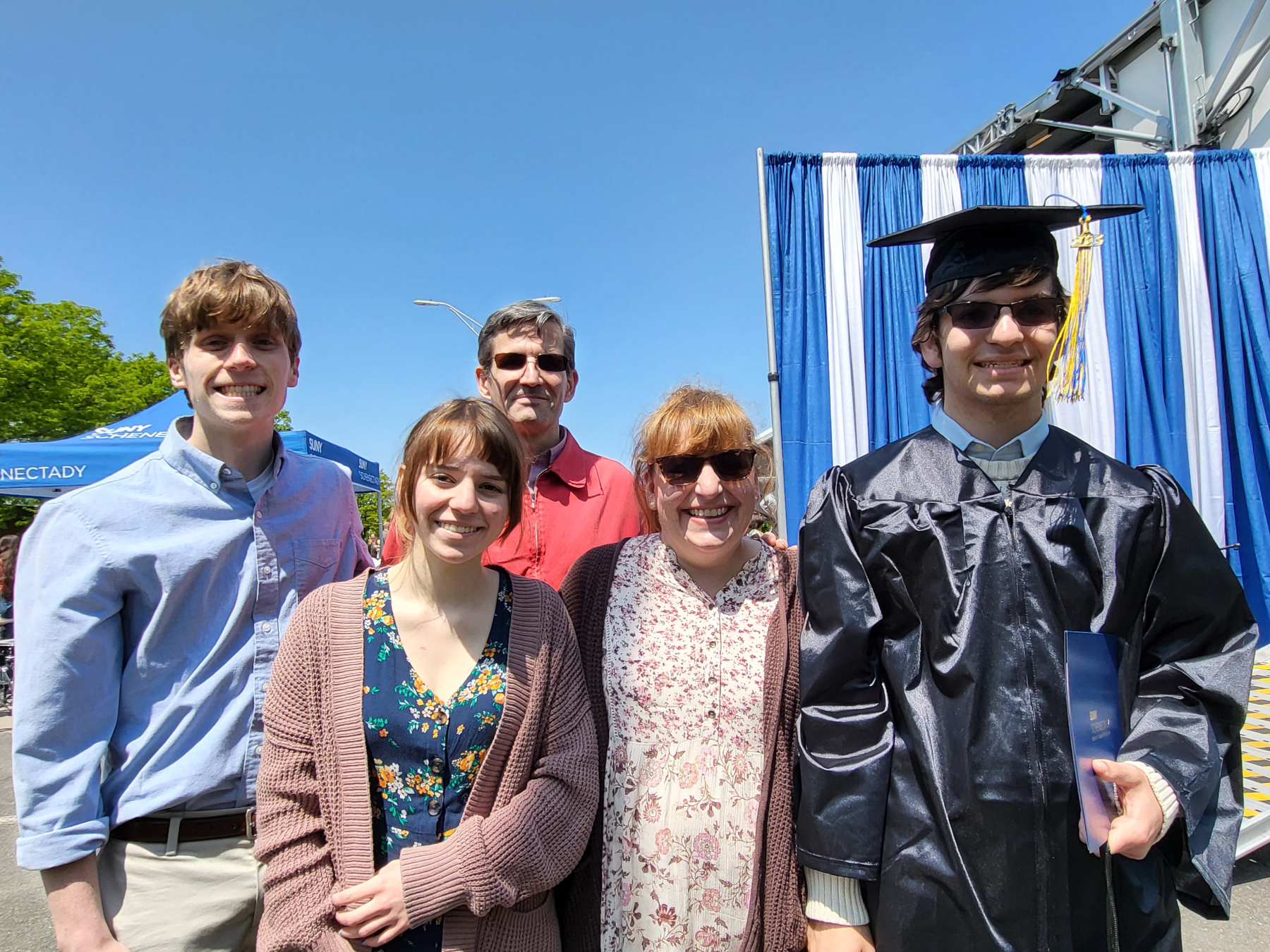Graduate and family, standing, smiling