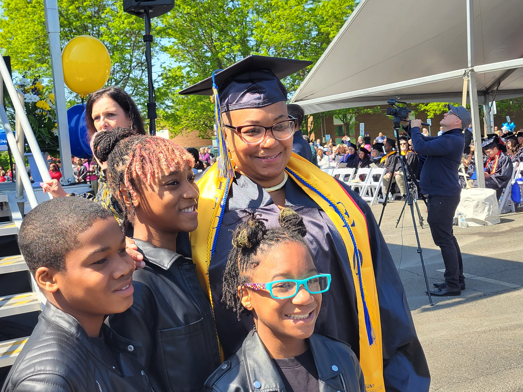 Graduate with children, smilng