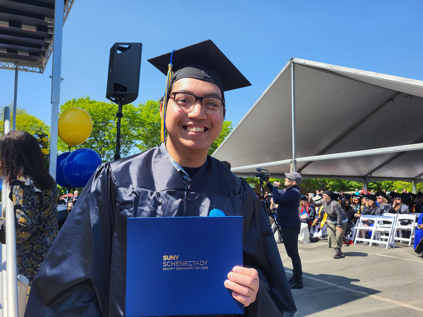 Happy graduate holding their diploma after stepping off the stage.