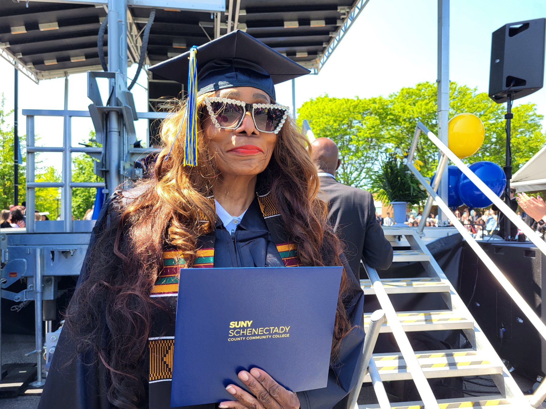 Faith Byrd, holding degree after crossing stage, smiling