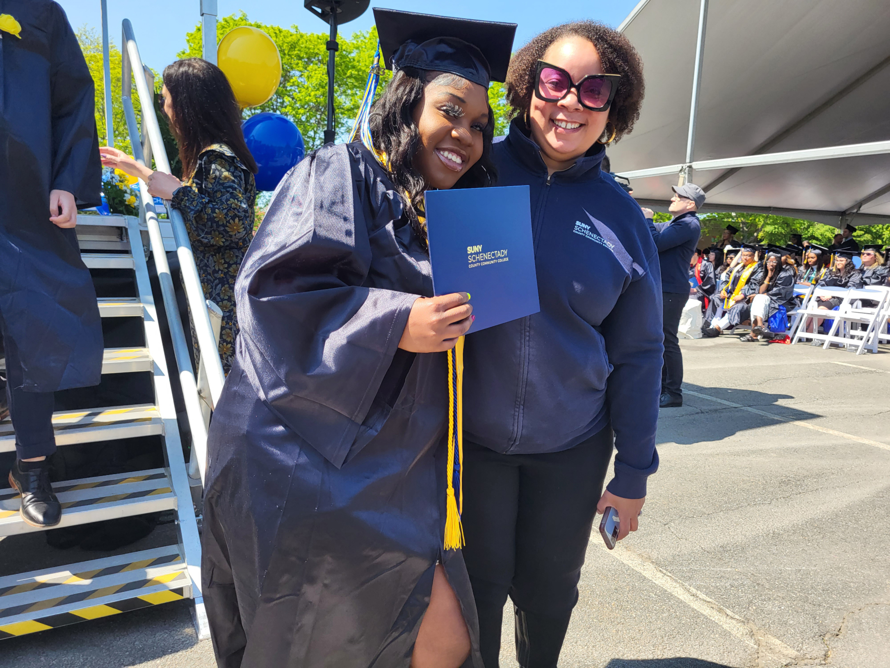 Graduate being congratulated by Tiombe Farley after crossing stage