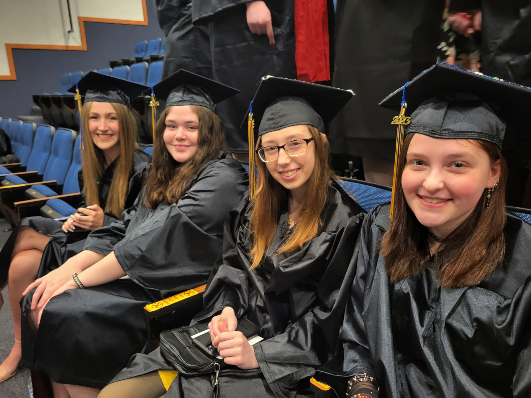 Graduates sitting in auditorium, smiling