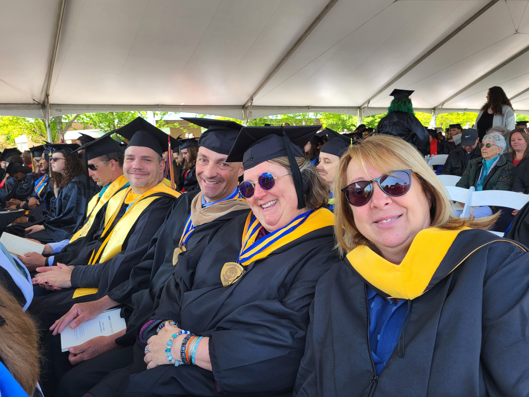 Faculty seated, smiling