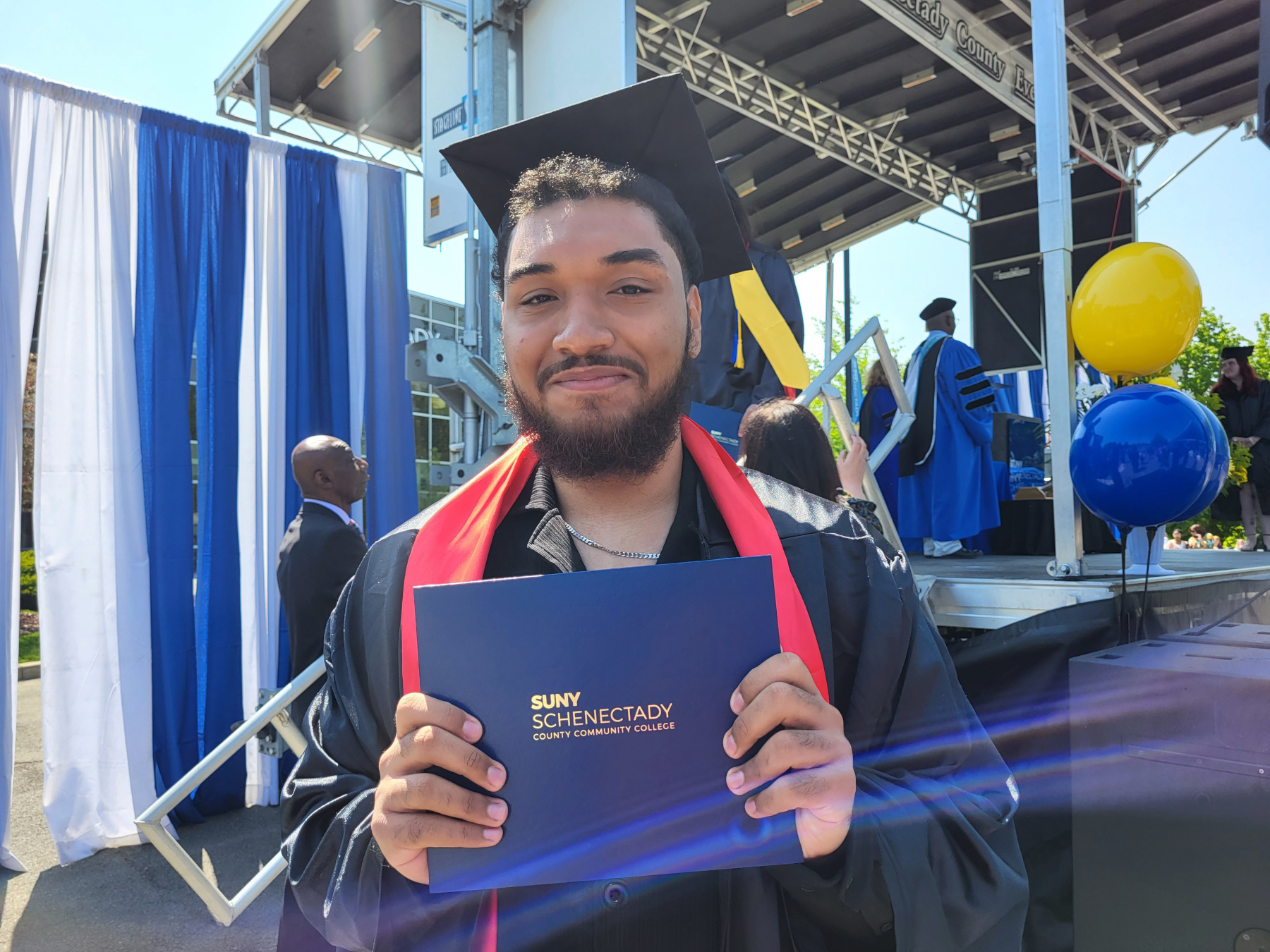 Graduate smiling holding degree