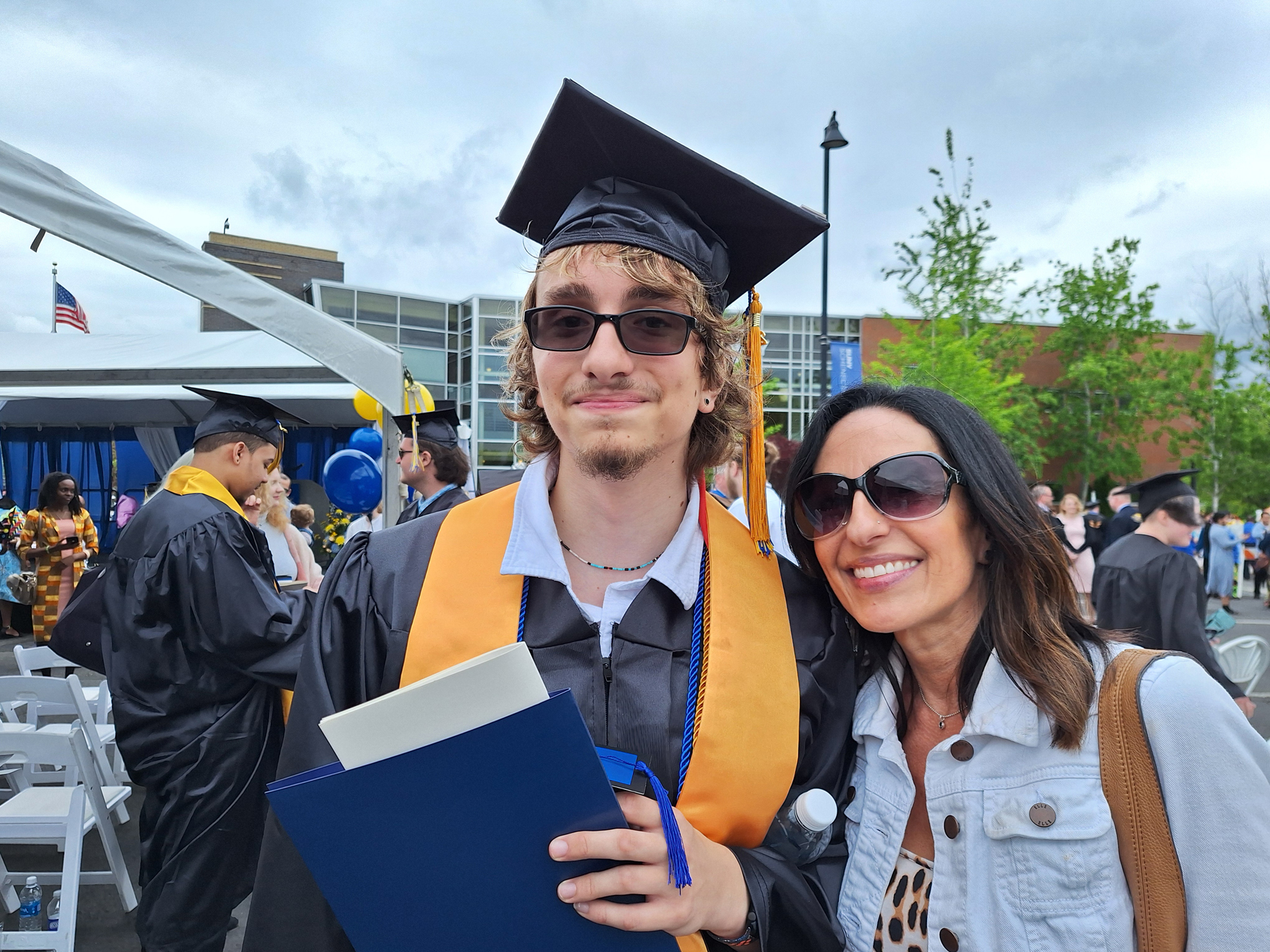 Graduate and his Mom, outside, smiling
