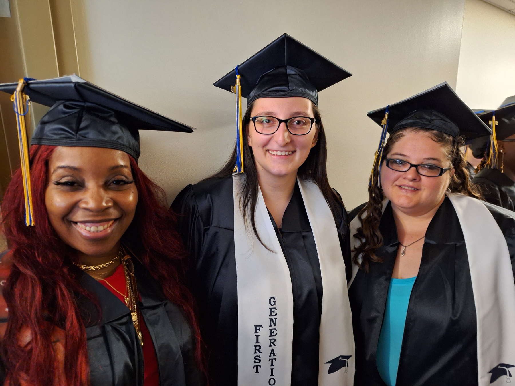 Three graduates outside smiling