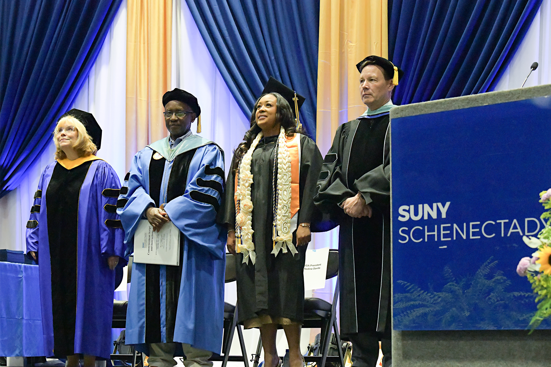 College officials standing on stage