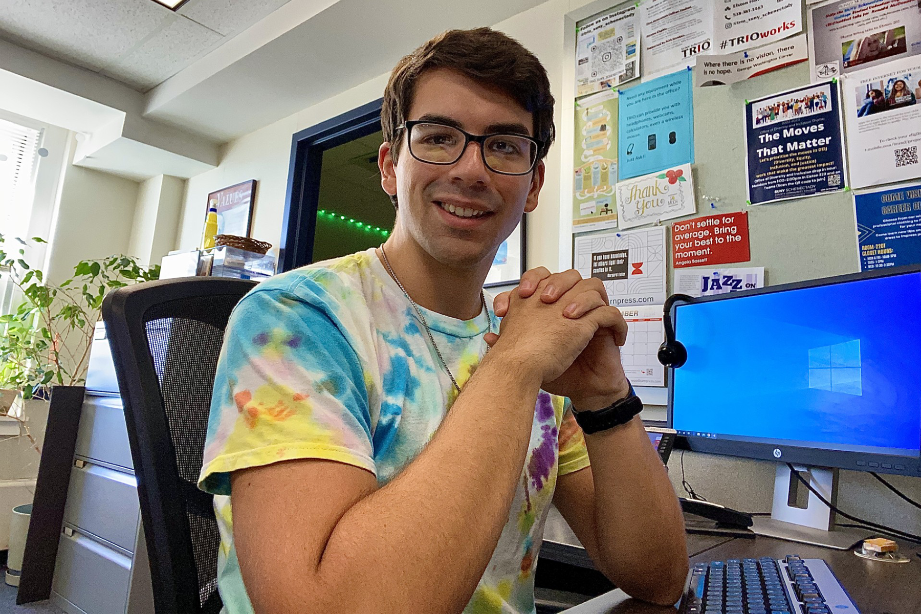 Corey Bub sitting at desk, smiling