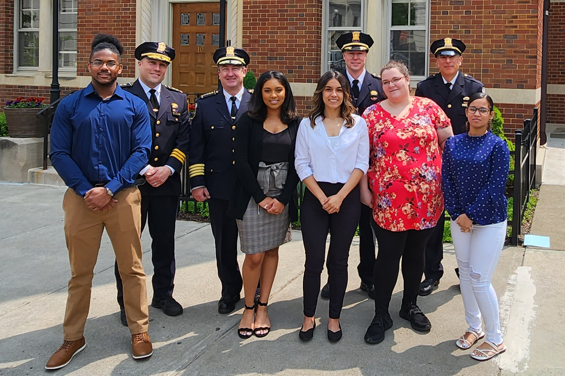 Criminal Justice students with law enforcement professionals outside during New York State Police Officers Memorial event