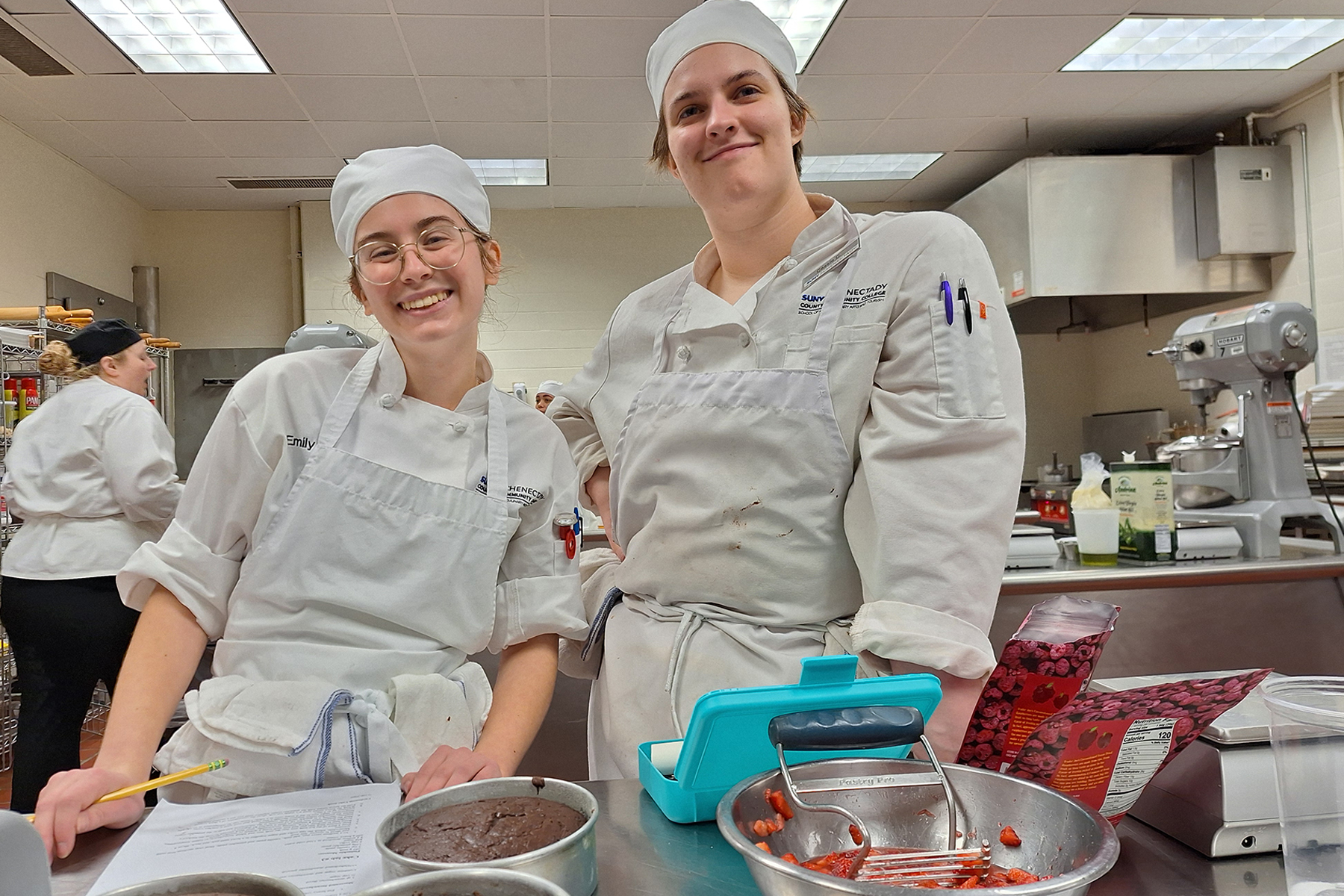 Two students in uniform in baking lab