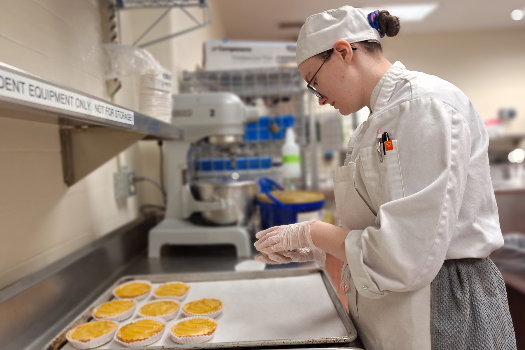 Student in uniform, making pastry in baking lab