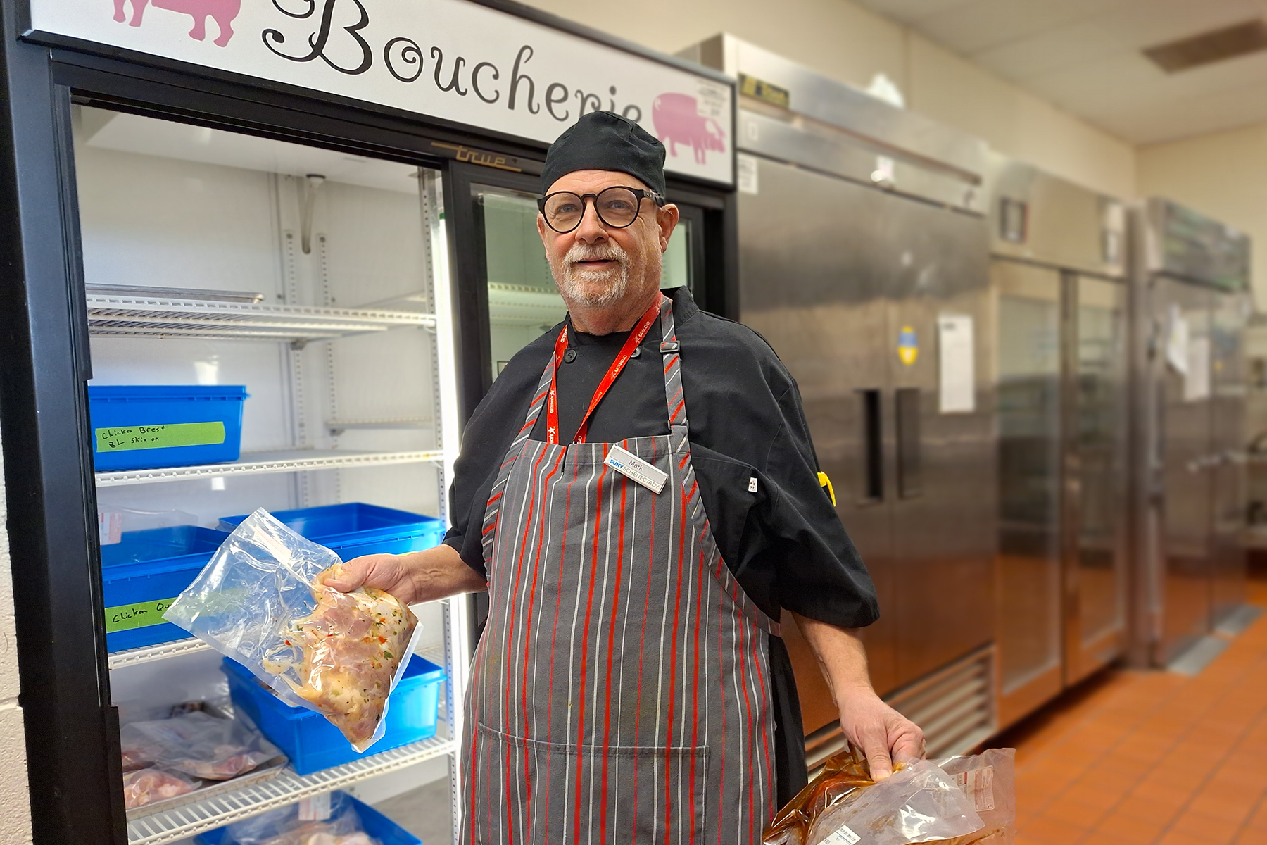 Staff member standing near coolers inside The Boucherie