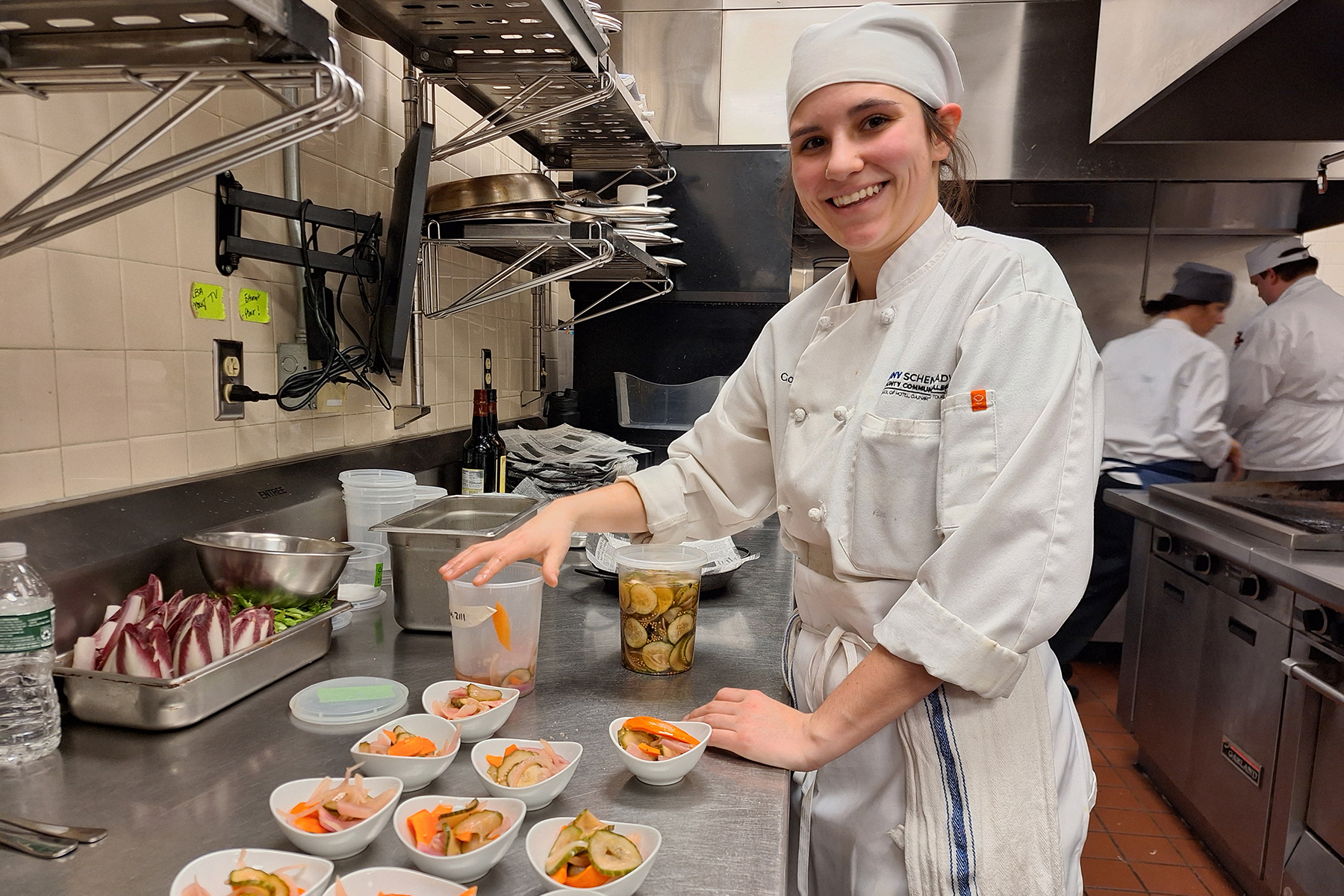 Student in uniform preparing food in Culinary Lab