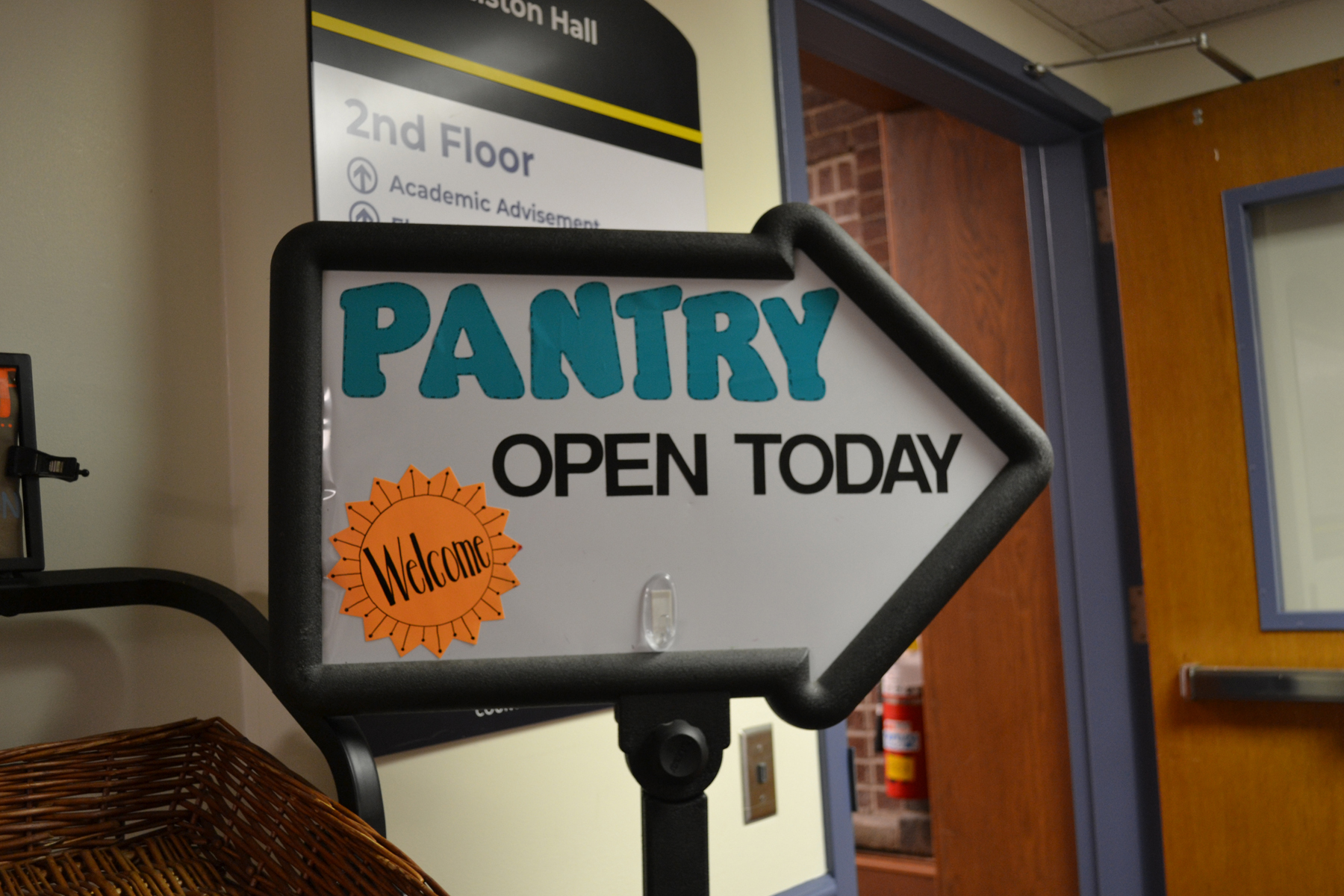 Food Pantry welcome sign pointing to entrance of Food Pantry