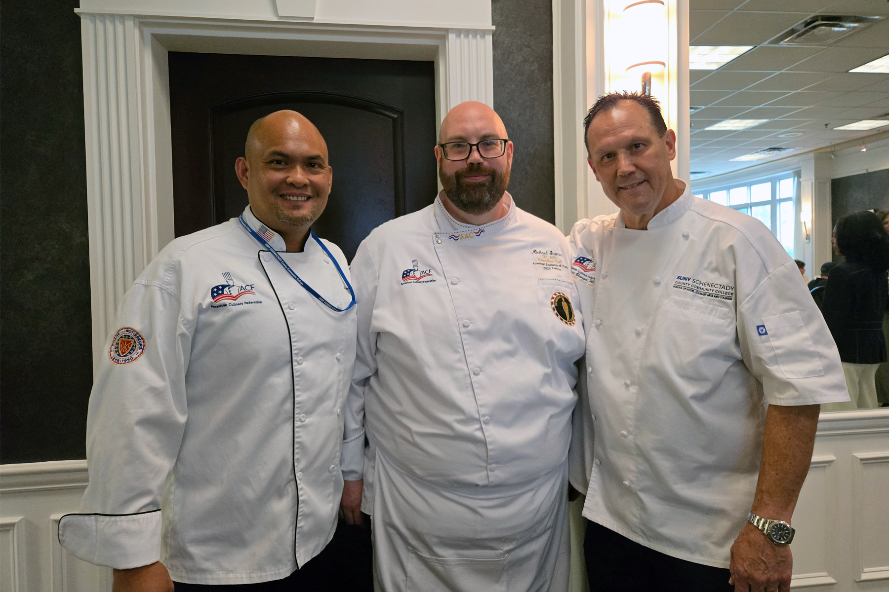 Chefs Gio Lontoc, Michael Stamets, and Dr. David Brough, smiling, inside the Casola Dining Room