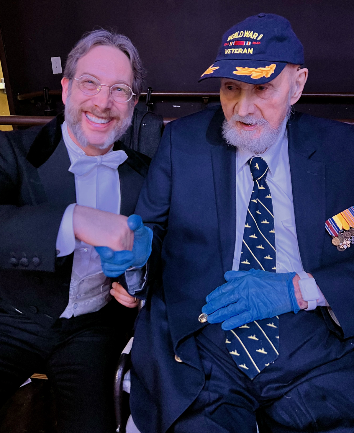 Dr. Brellochs in tuxedo shaking hands with Ambassador J. William Middendorf II