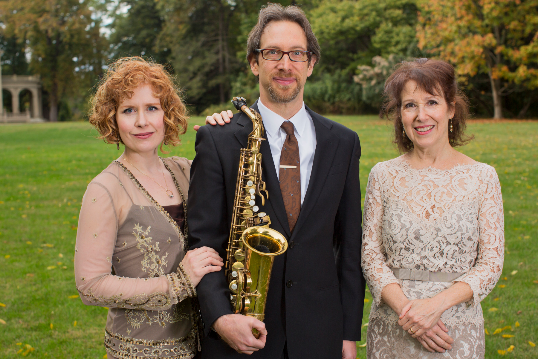 Dr. Christopher Brellochs holding saxophone in middle with his wife Elizabeth Gerbi, soprano, and Cynthia Peterson (right), piano, as they prepare for a performance at Crawford House (Newburgh, N.Y.).