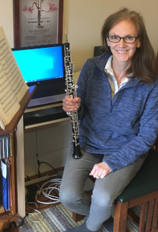 Professor Karen Hosmer seated at home holding oboe