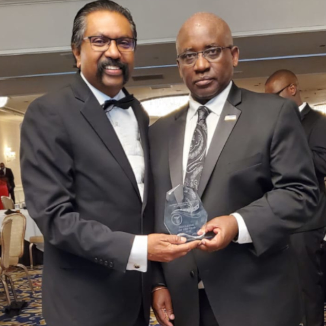 Dr. Moono holding ZANUS Award with Robert C. William, Founder and President/CEO of Pennsylvania Center for International Exchange and Partnership (PCIEP).