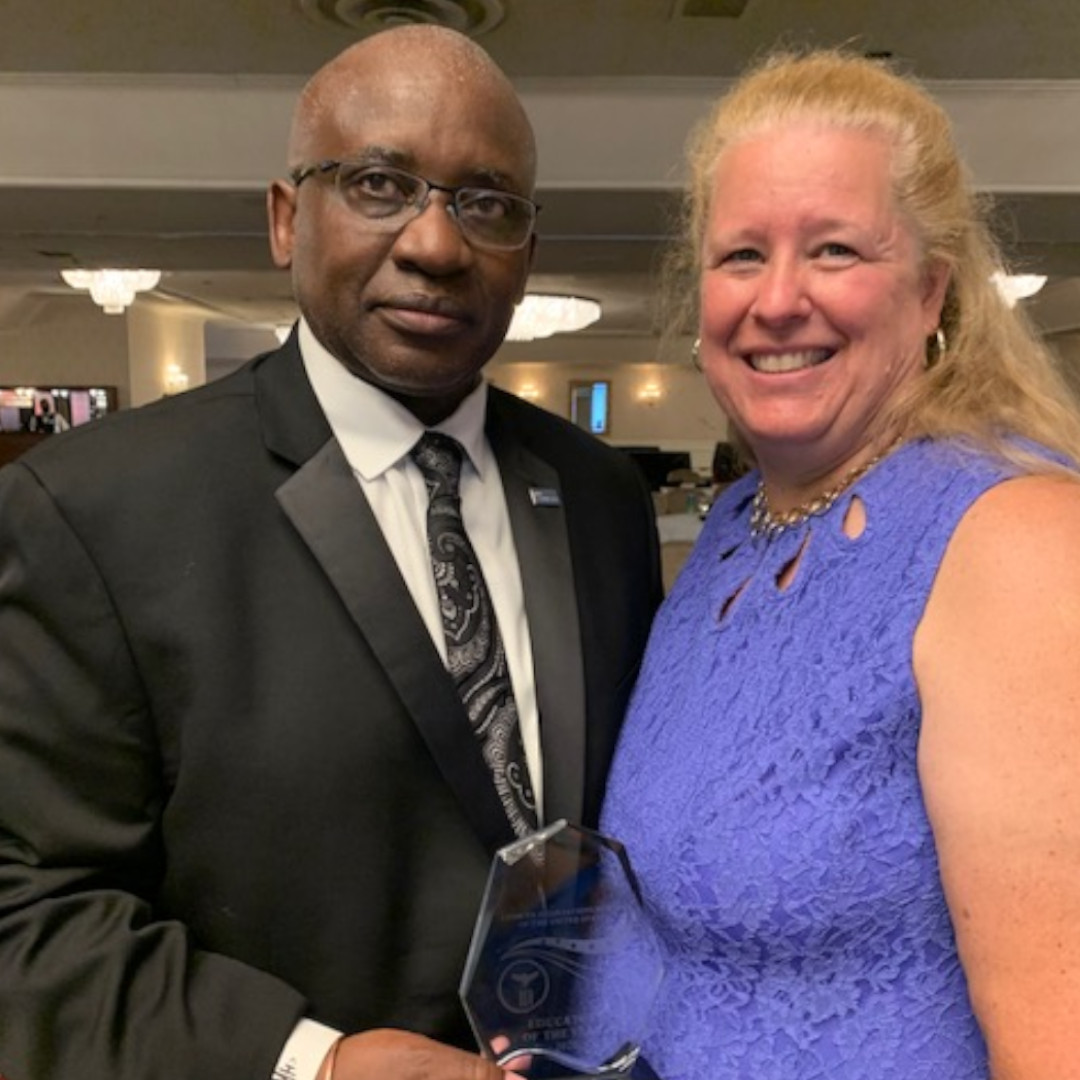 Dr. Moono and his wife Kelly smiling with ZANUS award