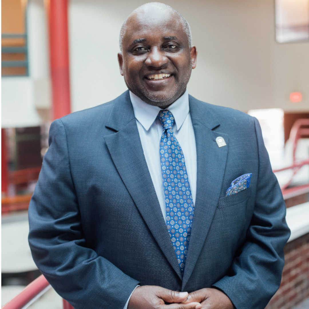 Dr. Steady Moono smiling, standing in Elston Hall