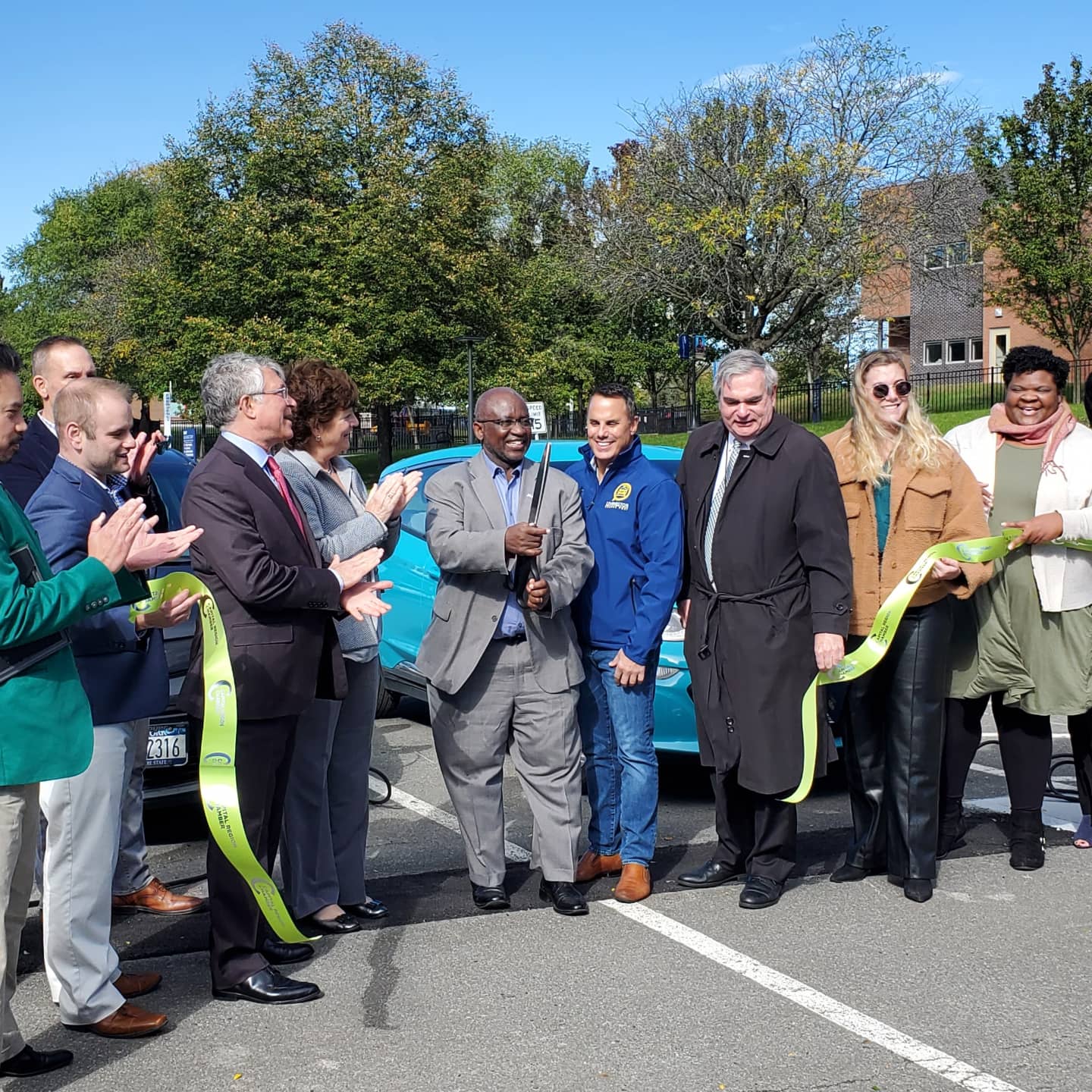 College reps and officials from National Grid, Schenectady, etc. cut ribbon for new EV charging stations