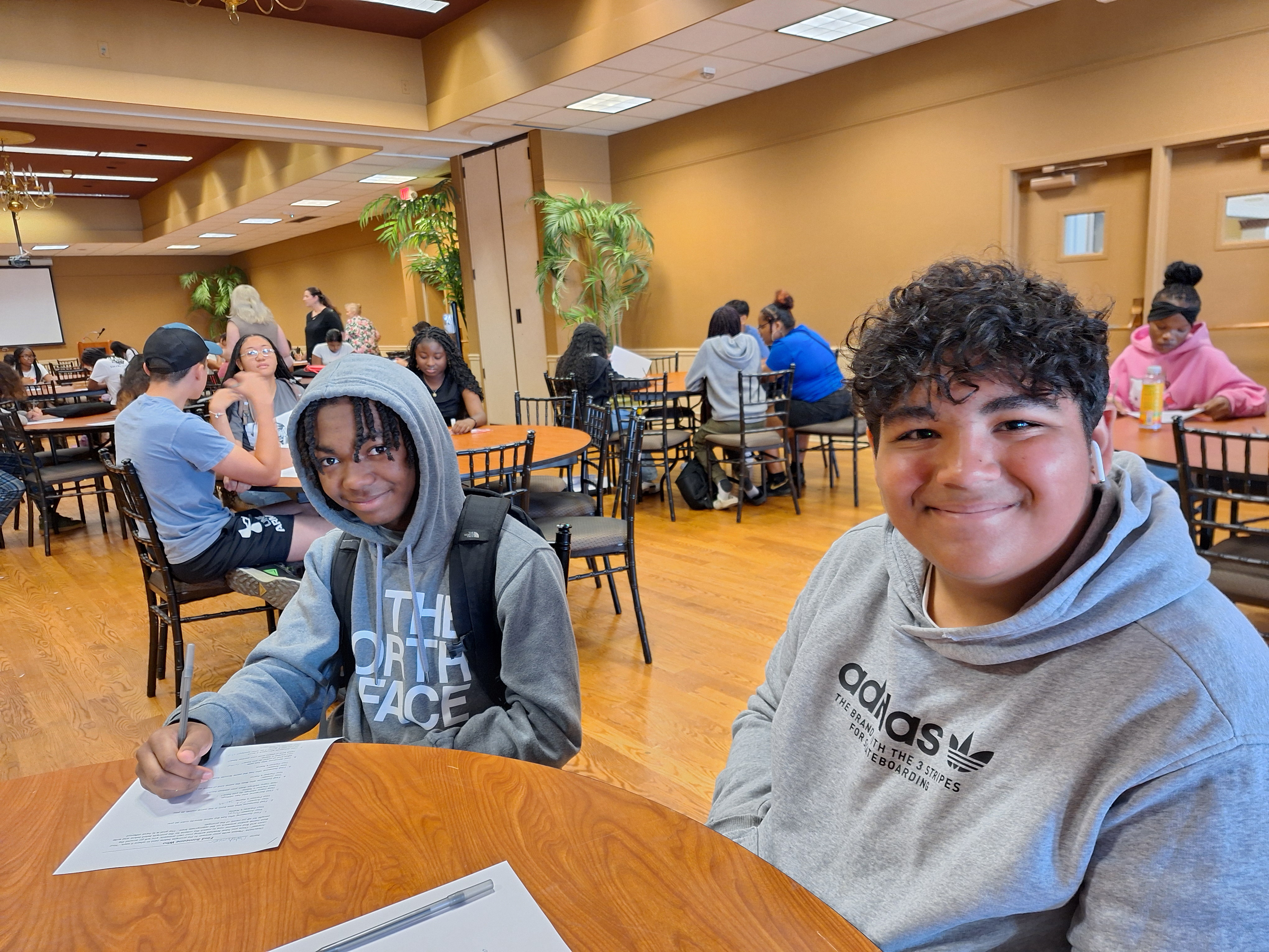Two students sitting at table, smiling
