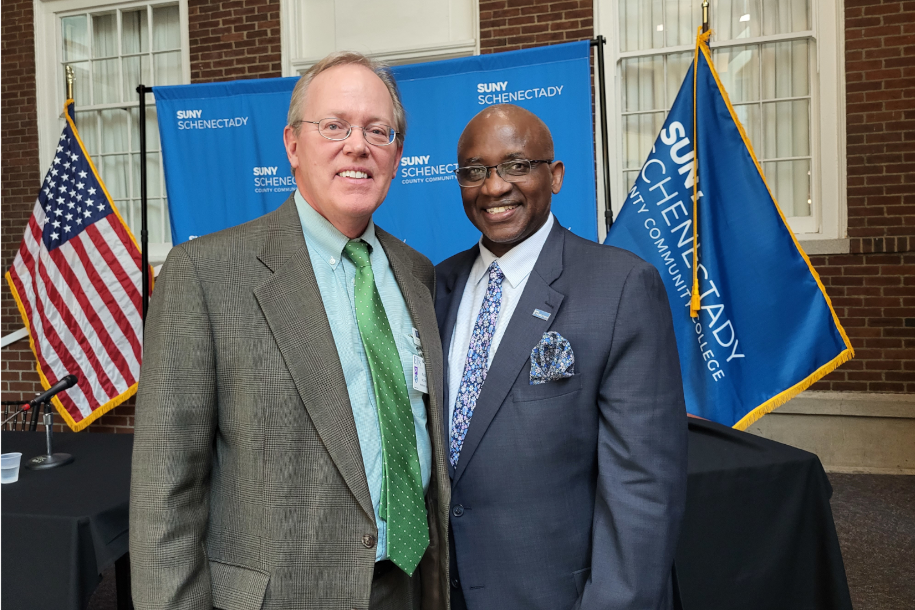 Dr. Steady Moono and Paul Milton standing, smiling after agreement signing