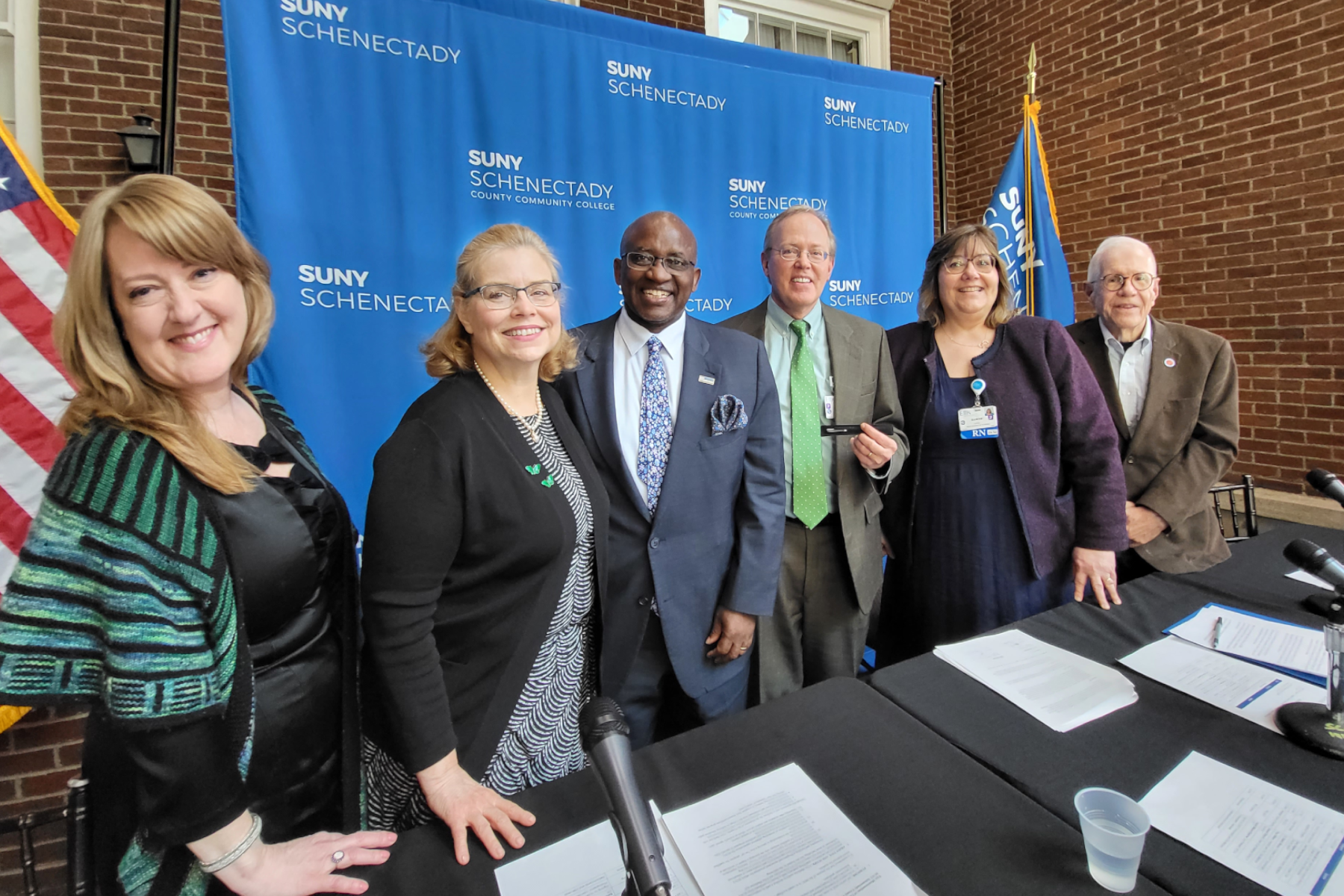 Officials from Ellis Medicine and SUNY Schenectady standing, smiling with college backdrop behind them