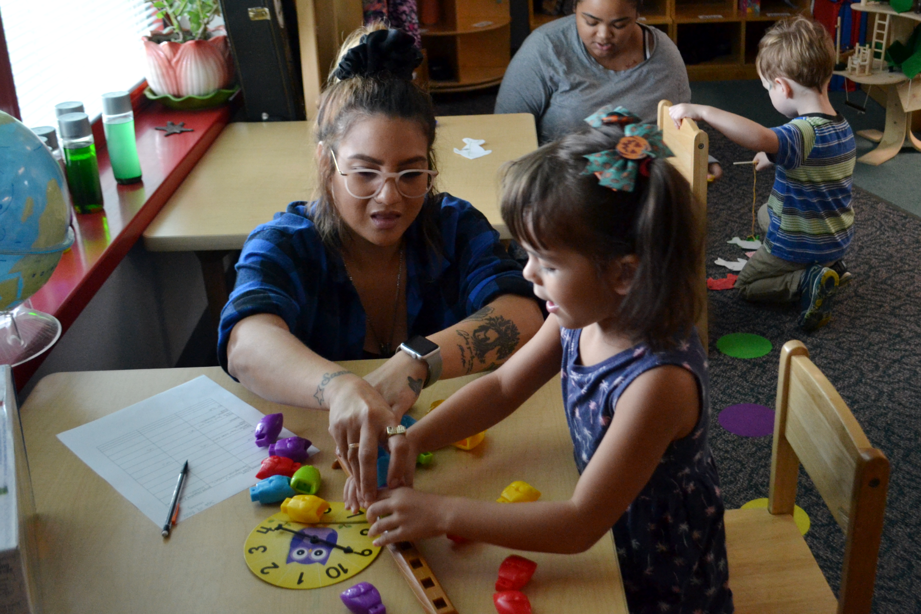 Emylie Montalvo and child counting owl toys on table