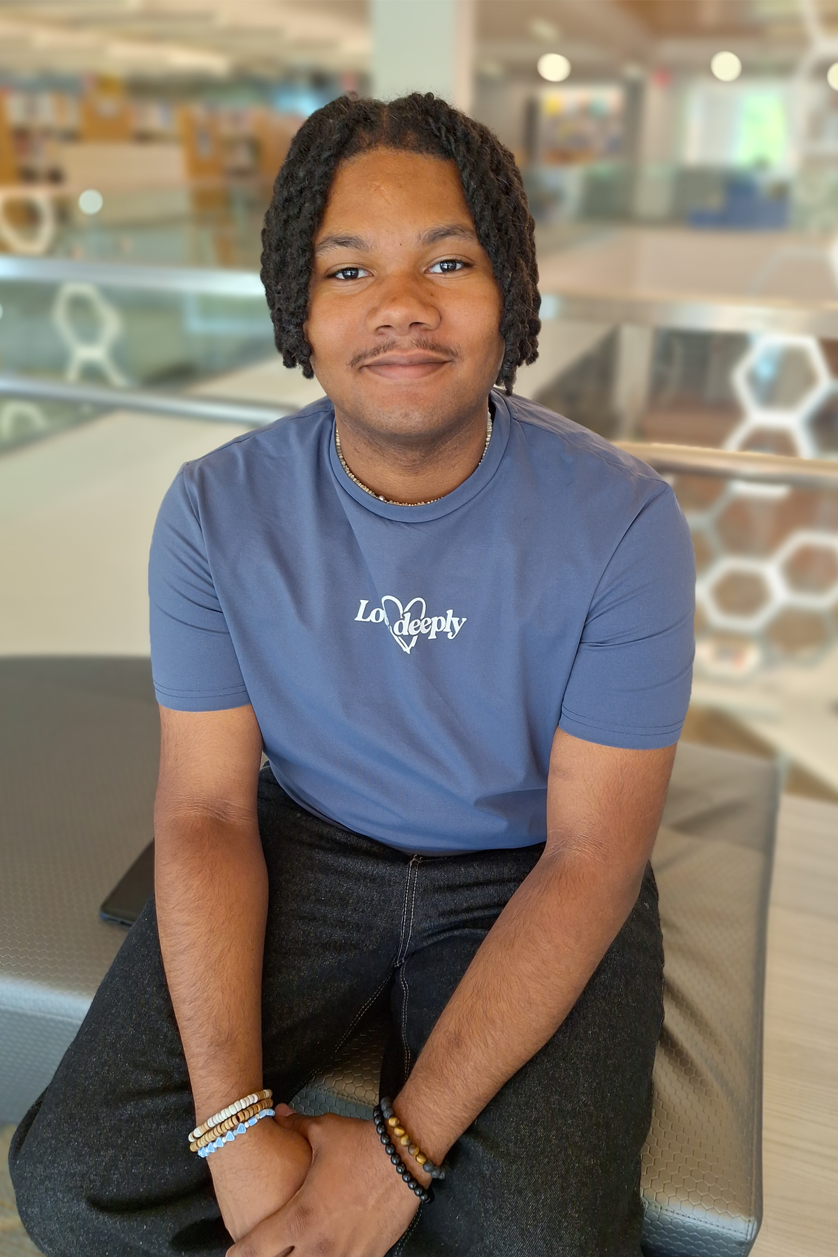 Eric Cortes, sitting in Learning Commons, smiling