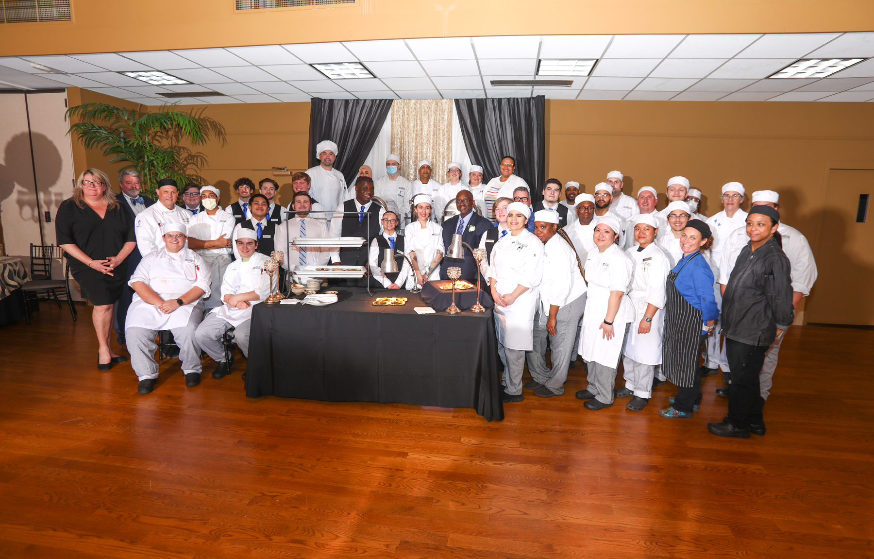 Student chefs, Dr. Moono and faculty posing for photo in Van Curler Room