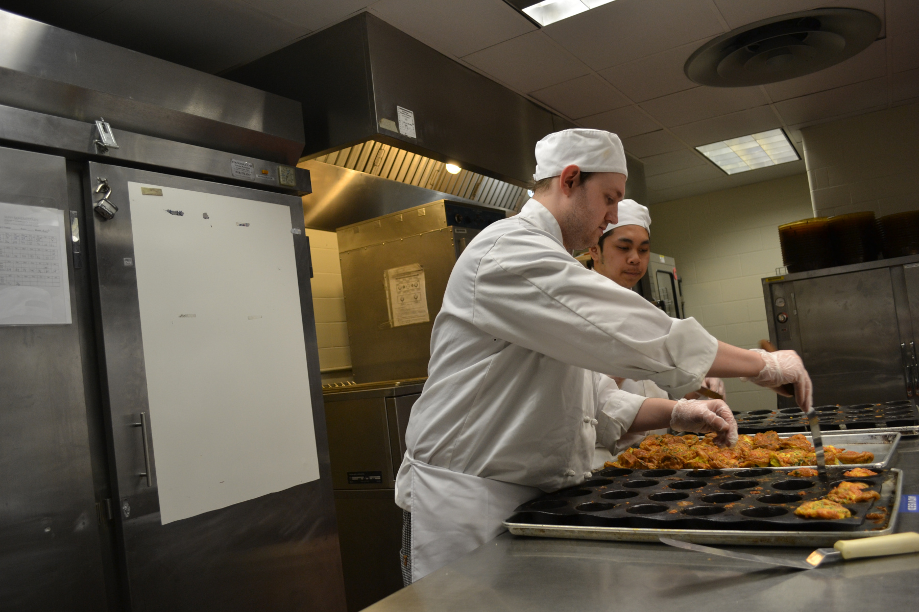 Karl Lutz and Godfrey Garzon cooking in Culinary Arts Lab.