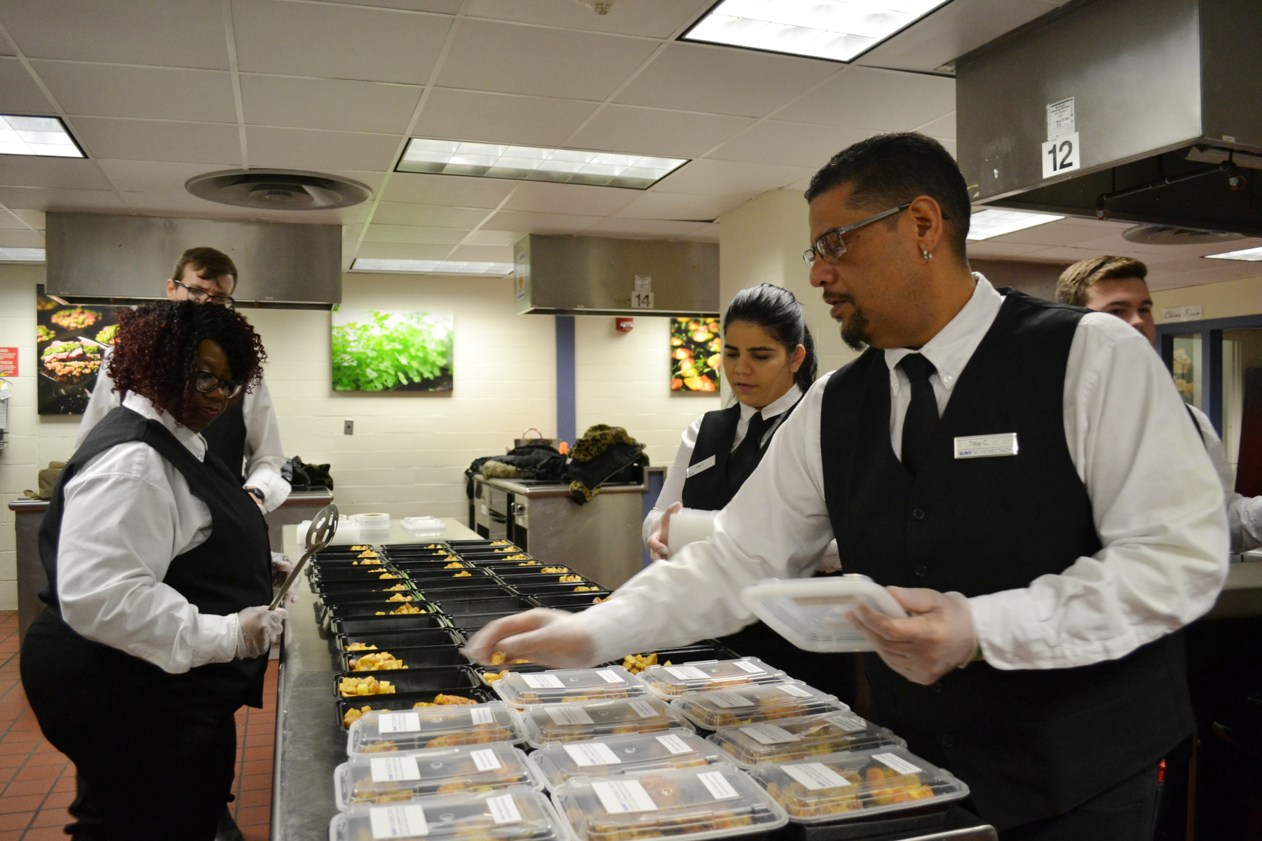 Student in Culinary Arts Lab assembling meals for Feed Albany.