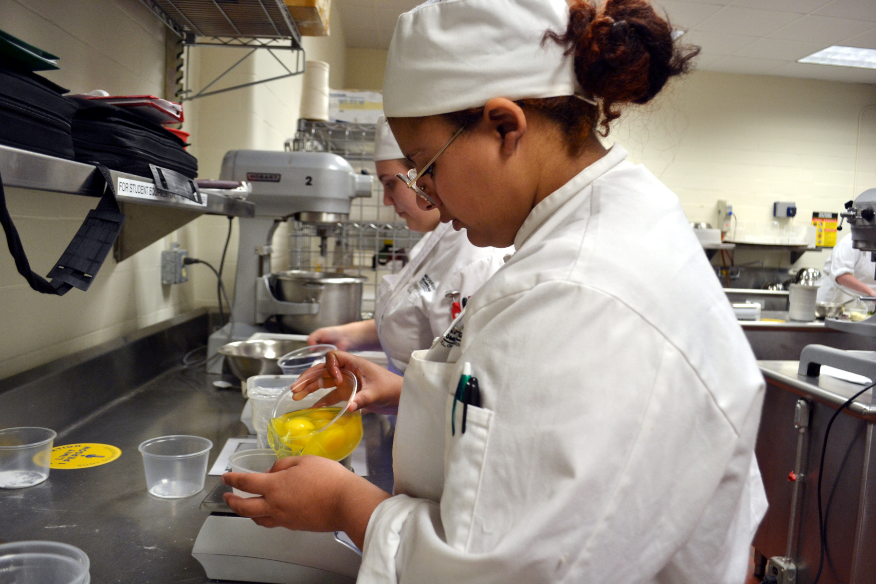 Student separating eggs to make pastries in Pastry Lab