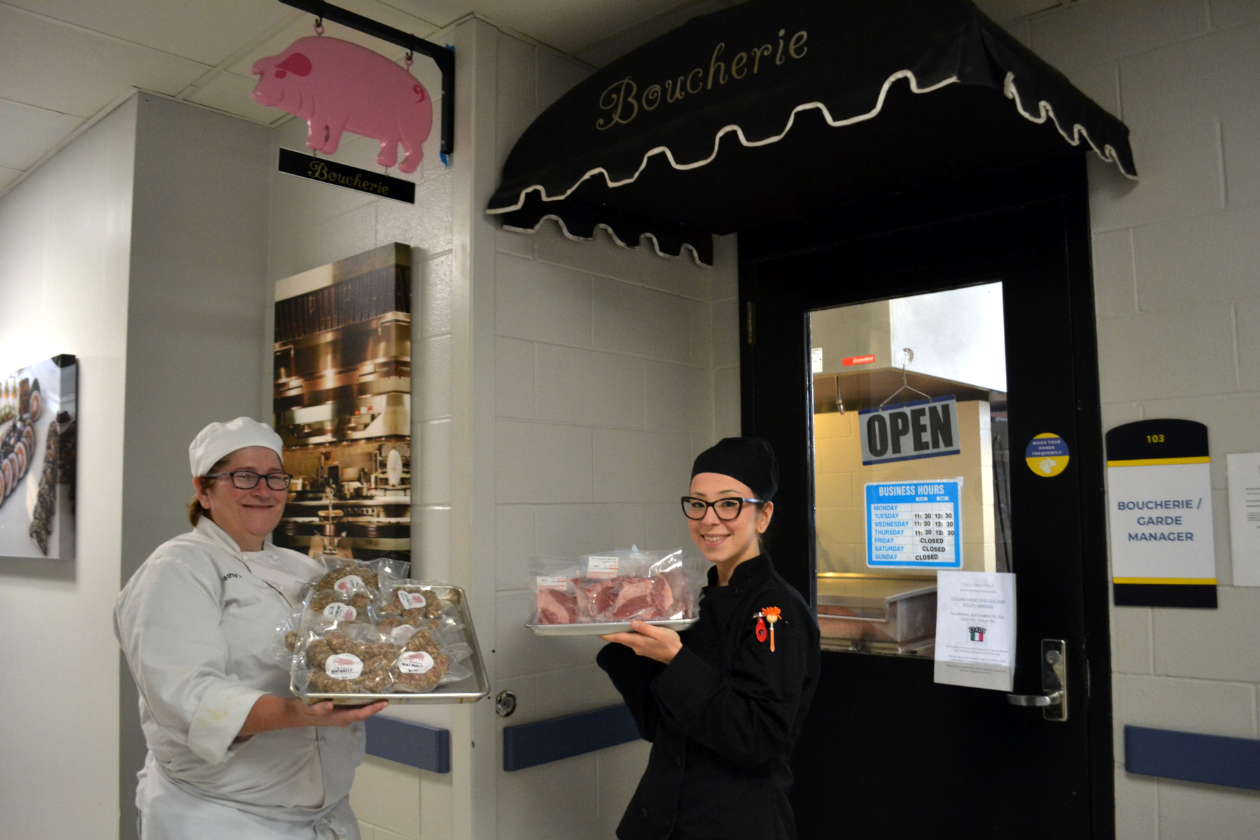 Faculty member and student standing holding products in front of the Boucherie