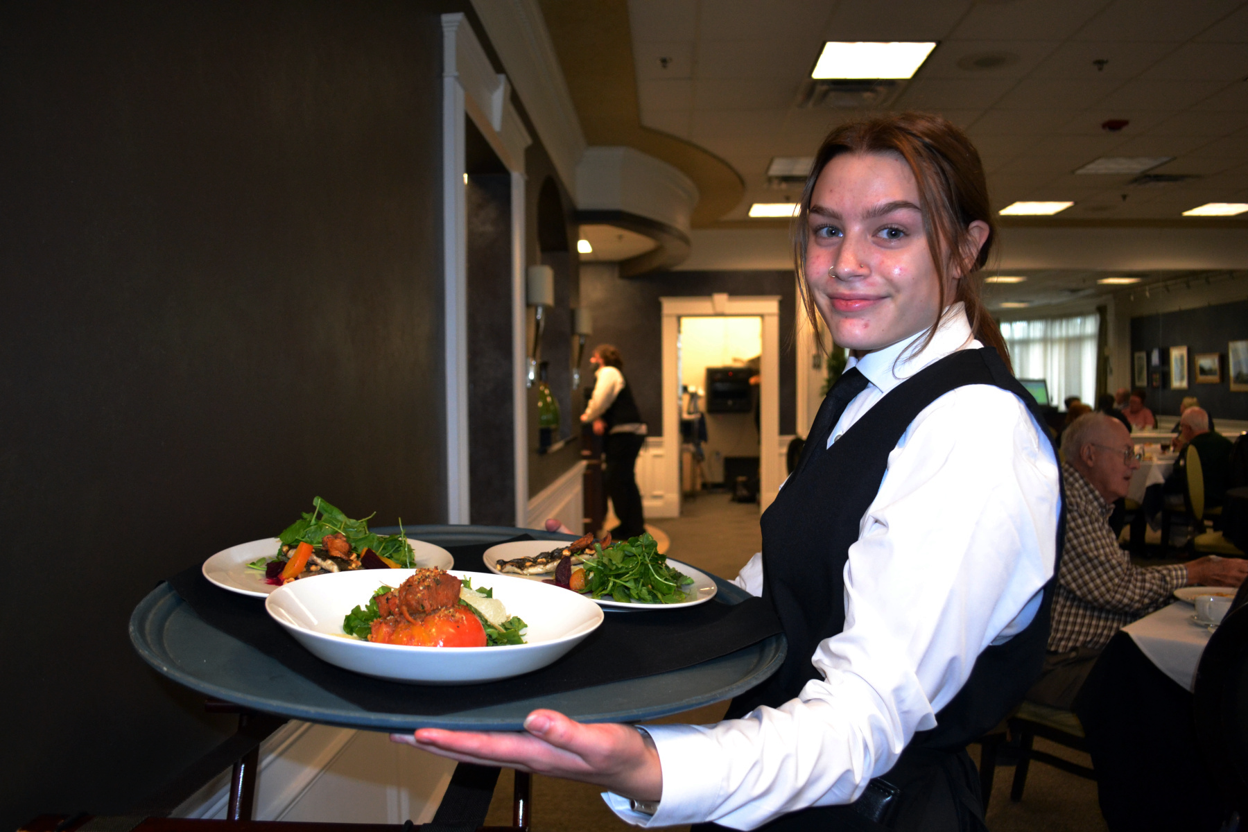 Student holding tray of cuisine in Casola Dining Room