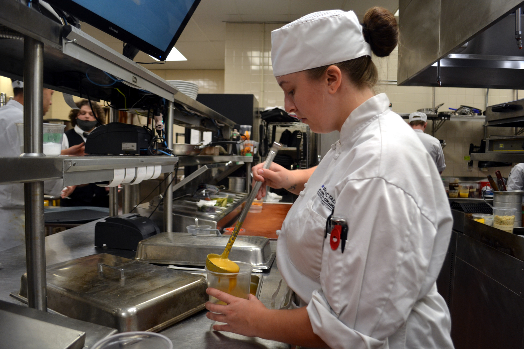 Student pouring soup in Culinary Lab