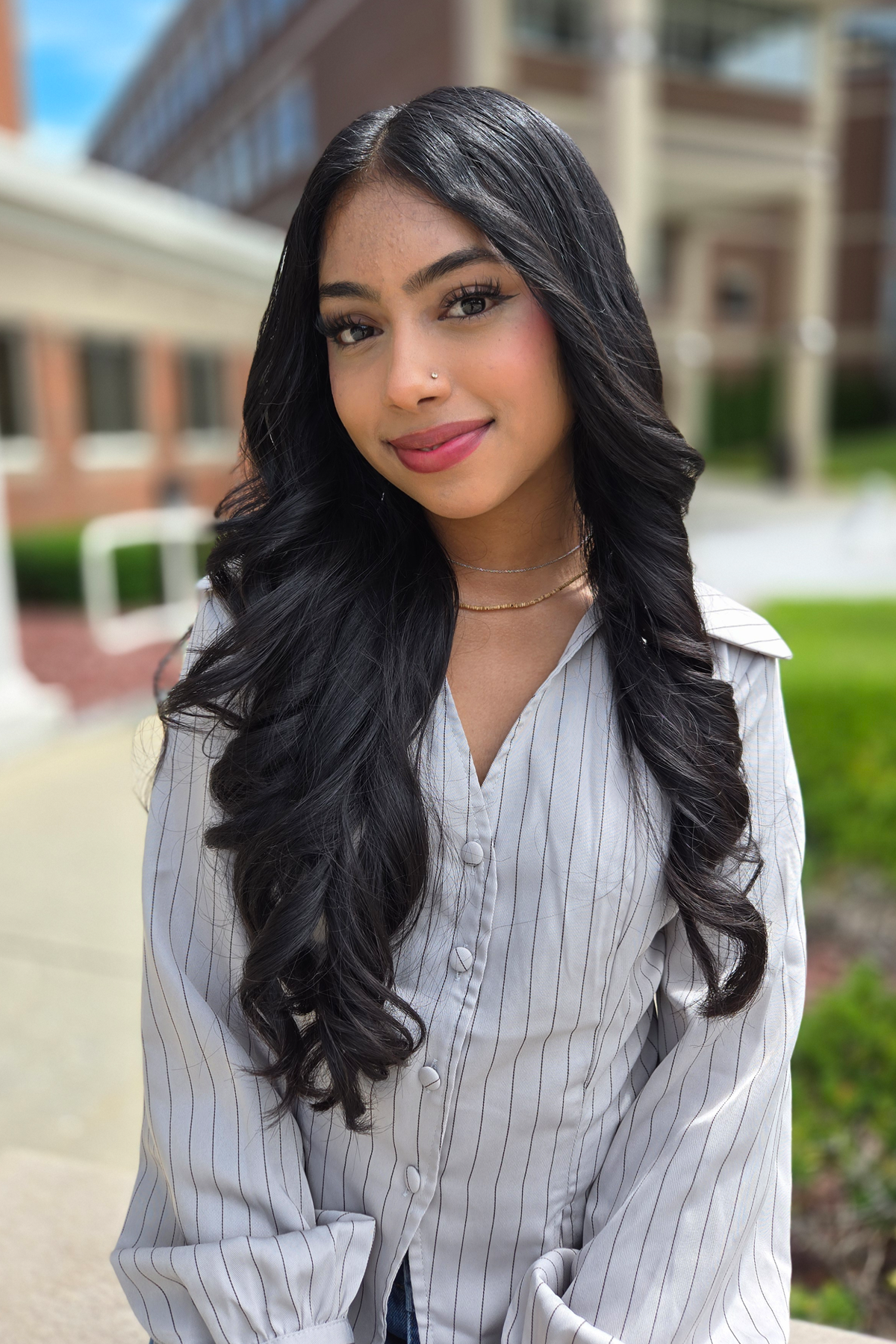 Hema Singh, sitting outside in The Quad, smiling