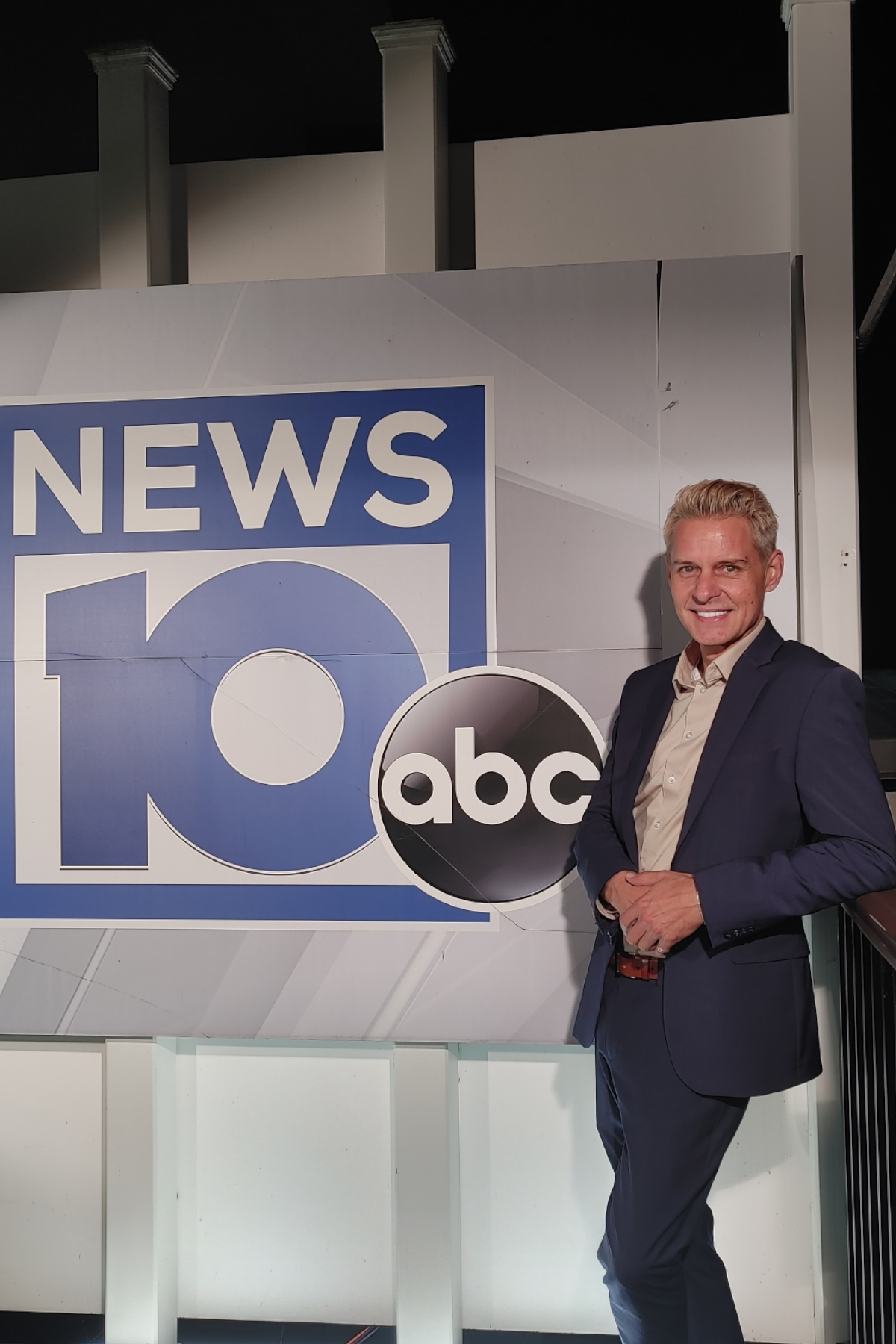 James De La Fuente smiling, standing in front of NEWS10 ABC logo