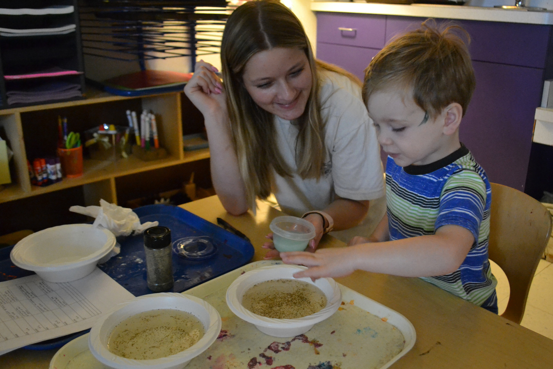 Student Jennifer Marra with child at table in preschool
