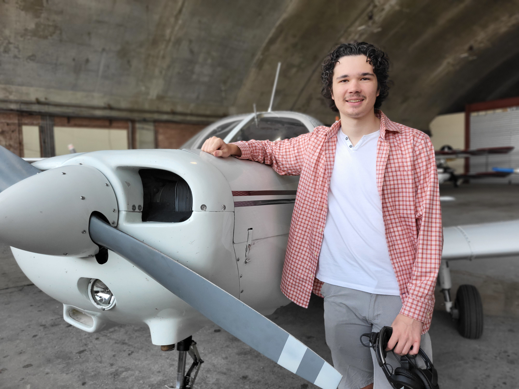 Jonathan Ryan standing next to airplane, smiling