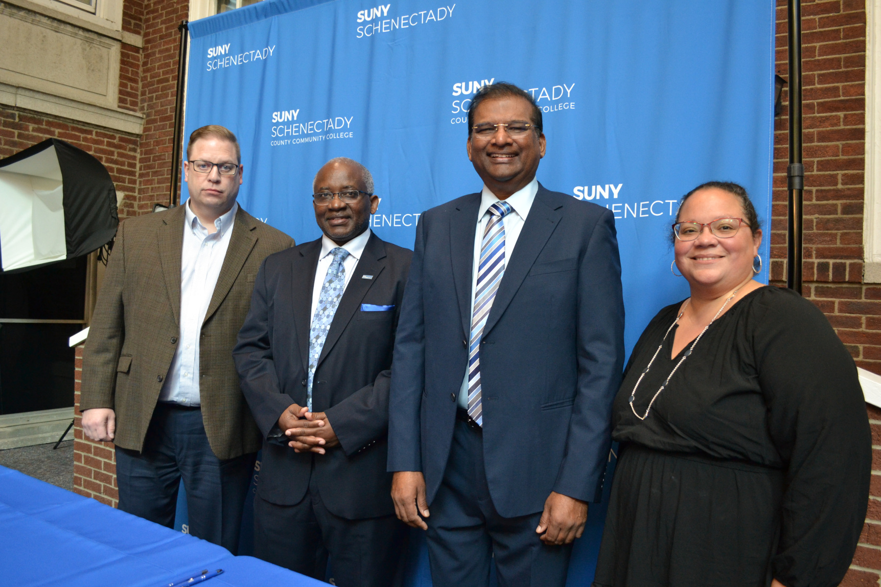 Officials from SUNY Schenectady and Karunya Institute of Technology and Sciences (KITS) standing in front of SUNY Schenectady backdrop