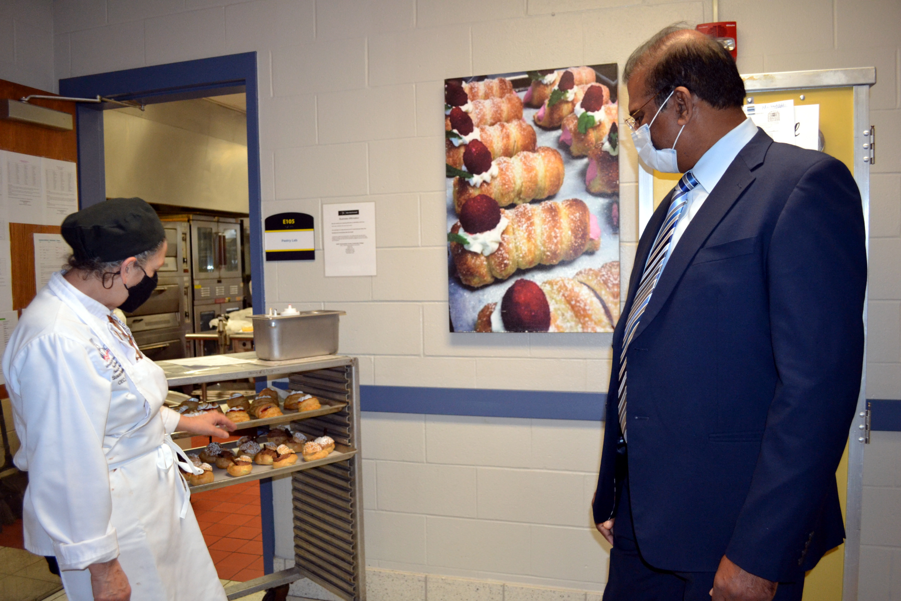 Chef Susan Hatalsky, Baking Professor, showing Dr. Dhinakaran baked items here students have created.