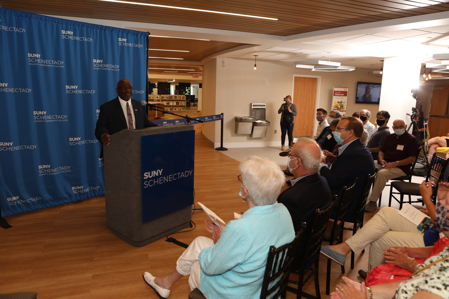 Dr. Moono at podium talking to donors during Grand Opening