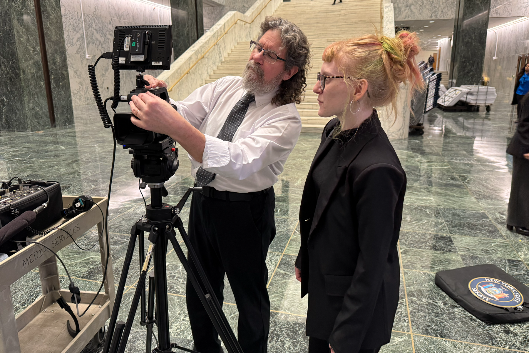 Eric Hoppel showing Madison Webb how to operate camera 